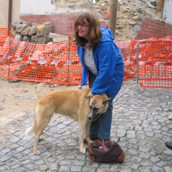 Ria in una delle zone rosse coccola un cane randagio.
